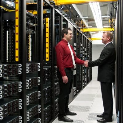 two men shaking hands in a server room